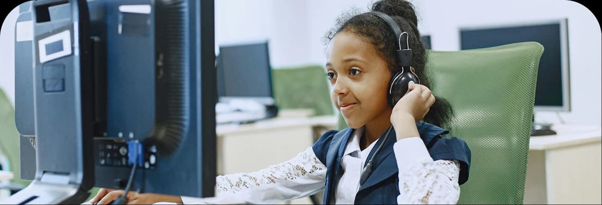 Young girl learning on a computer in a classroom