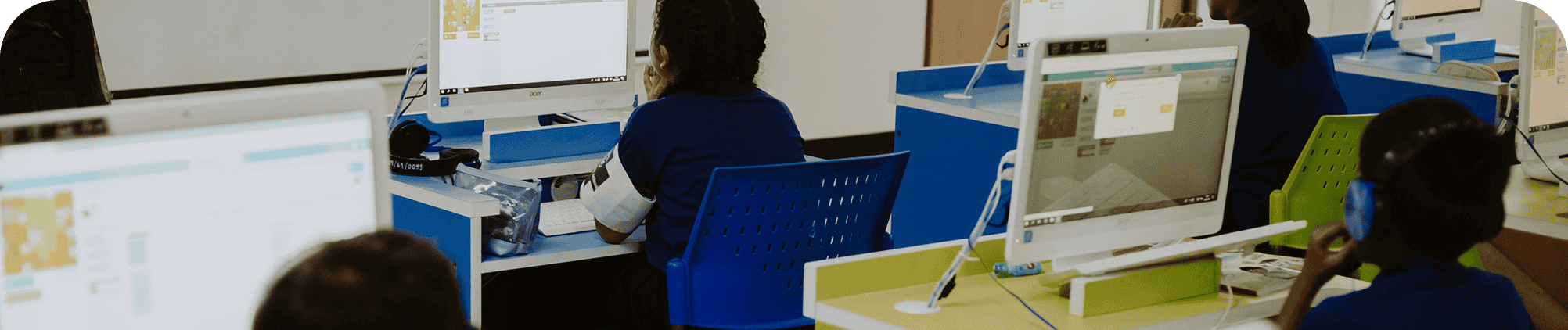 Students learning on desktop computers in a digital classroom